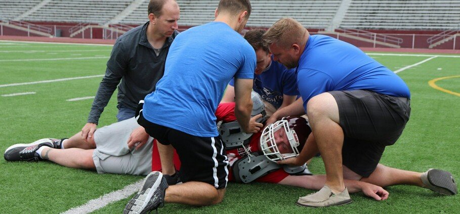 athletic-trainers_efcb56947f6b032f30446a1a9423b77a athletic trainers helping an injured football athlete